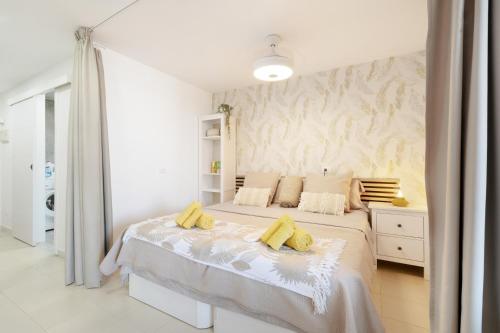 a bedroom with a bed with yellow pillows on it at Infinity Summer in San Miguel de Abona