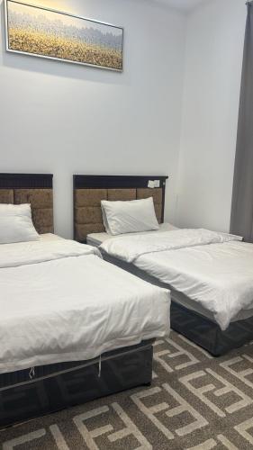 two beds sitting next to each other in a room at شقة فاخرة بغرفتين نوم وصالة ومجلس in Abha