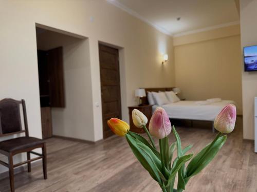 a room with a bed and a vase with flowers at Lalaner Hotel in Sisian