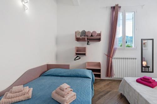 a bedroom with a blue bed and a window at Il Leone Bianco Affittacamere in Albenga