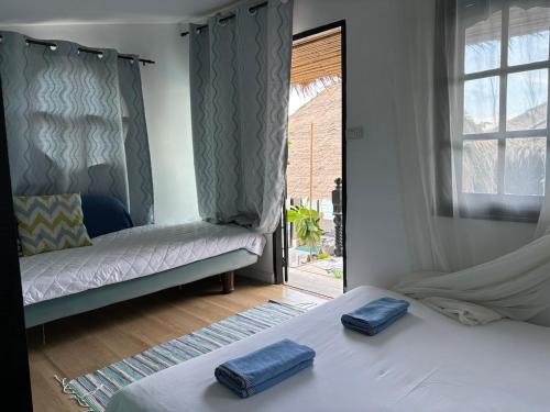 two twin beds in a room with a window at The Boathouse in Bang Sare