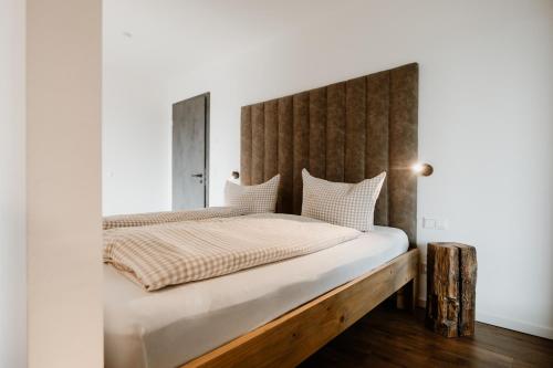 a bedroom with a large bed with a wooden headboard at FourElements Grand Chalet in Blankenburg