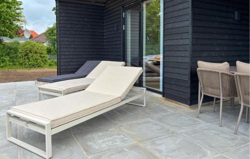 a patio with two white chairs and a table at 4 Bedroom Cozy Home In Haderslev in Haderslev