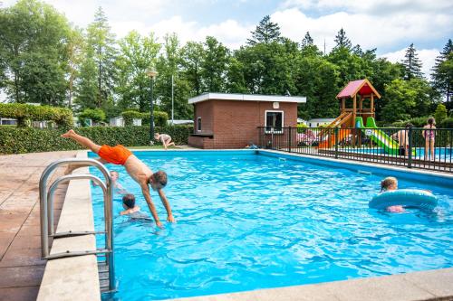 a boy jumping into a swimming pool at Recreatiepark Goorzicht in Aalten