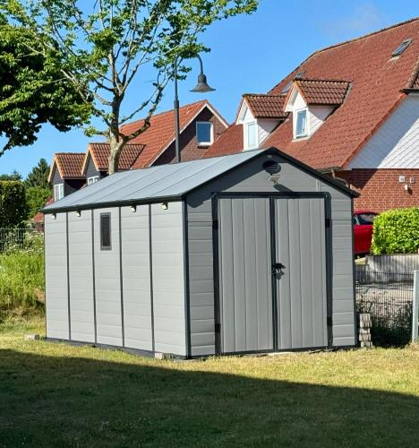 a large white shed with a black roof at Pier 76 in Scharbeutz