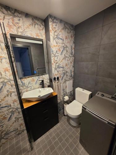 a bathroom with a toilet and a sink and a mirror at Külaliskorter Aardla tn 120 in Tartu