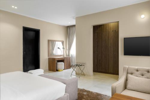 a bedroom with a bed and a tv on a wall at Metro Apartments in Lagos