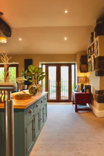 a kitchen with a counter and a table in a room at Town Gate Cottage in Stainland