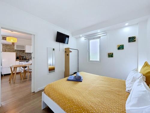 a white room with a bed and a kitchen at Casa Vereda Ponta Delgada, S Miguel in Ponta Delgada