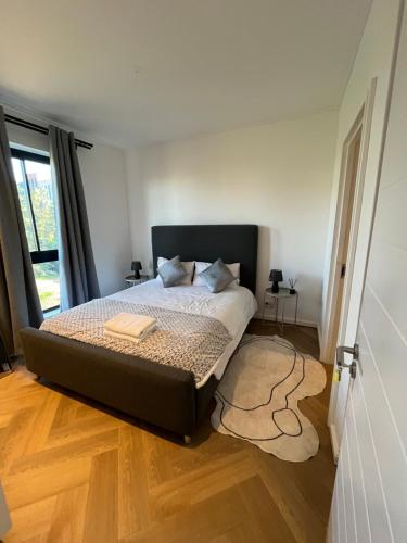 a bedroom with a large bed with a wooden floor at Silhouette Suite at Nine Palms in Cape Town