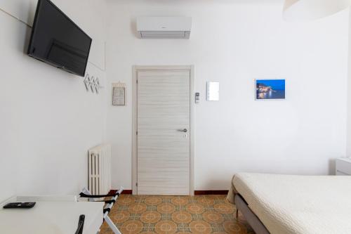 a bedroom with a bed and a desk and a television at Albergo NARDINI in Le Grazie