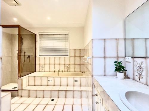 a bathroom with a tub and a sink at 3BR Retreat with Sunset Views over Brisbane Water in Green Point