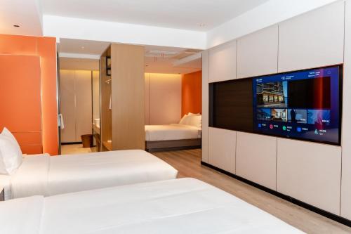 a hotel room with two beds and a flat screen tv at Jiuding Joy Hotel in Kathmandu