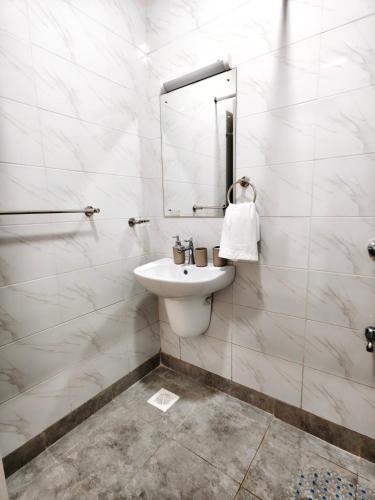 a white bathroom with a sink and a mirror at Chic One Bedroom Apartment near The Kenya School of Government - KSG in Nairobi