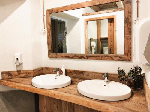 a bathroom with two sinks and a mirror at Locanda Teggiate in Madesimo