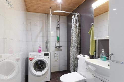 a bathroom with a washing machine and a sink at Moderni avara yksiö Jyväskylän ydinkeskustassa in Jyväskylä