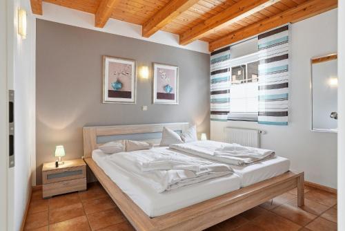 a bedroom with a large white bed in a room at Waterkieker in Greetsiel