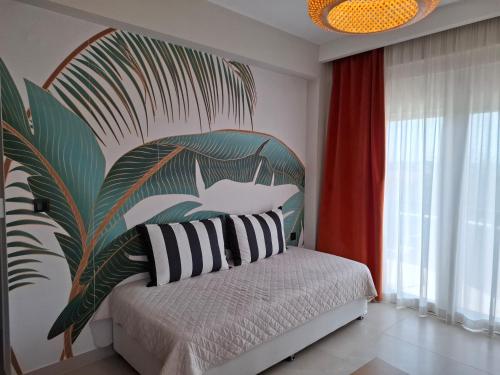 a bedroom with a bed with a large painting on the wall at Likehome Apartments in Orestiada