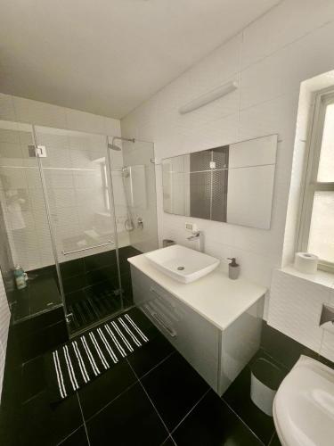 a white bathroom with a sink and a shower at Kosher Villa in earth of Moshava in Jerusalem