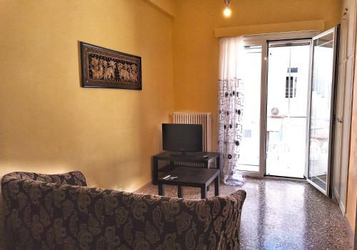a living room with a couch and a television at Amelie in Loutraki