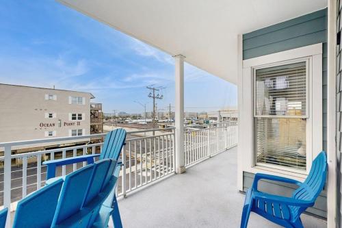 a balcony with two blue chairs and a window at Condo 4100 #201 in Ocean City
