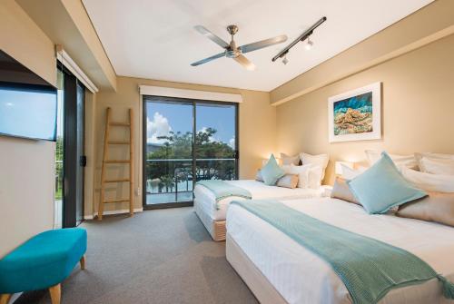 two beds in a room with a window at Darwin Waterfront Luxury Suites in Darwin