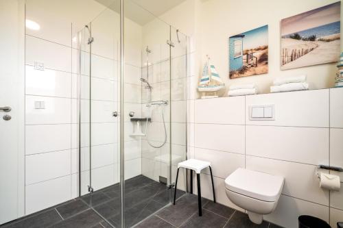 a bathroom with a shower and a toilet at Möwe - Apartment in der Hafenresidenz mit Balkon & Wellness in Waren