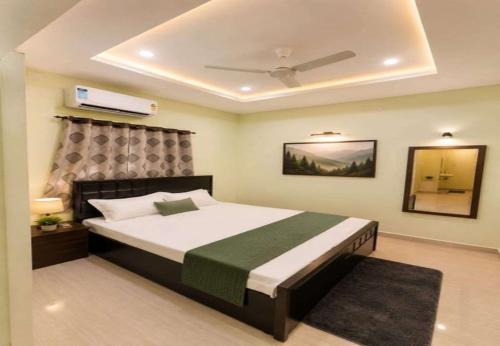 a bedroom with a large bed with a ceiling at Dev'S Inn Luxurious Homestays in Similigurha
