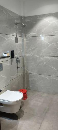 a bathroom with a white toilet and a shower at Hotel Bhasmaarti Ujjain in Ujjain