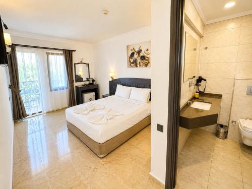 a hotel room with a bed and a bathroom at Kilim Hotel & Apart in Fethiye