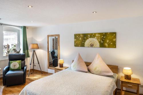 a bedroom with a bed and a chair at Ferienwohnung An der Wublitz in Leest