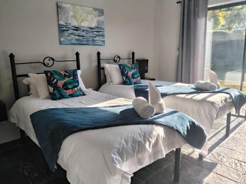 two beds with stuffed animals on them in a bedroom at Nylstroom Guesthouse in Modimolle