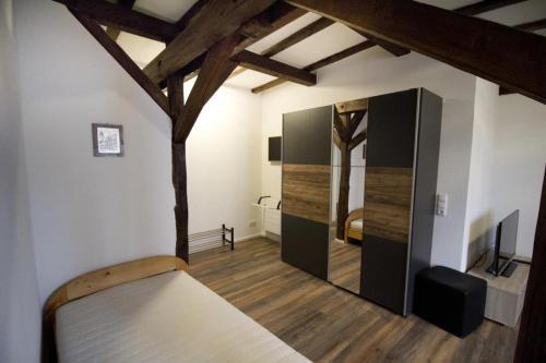 a bedroom with a bed in a room with wooden floors at NEU! Wohnung Balkenzimmer in Alsfeld