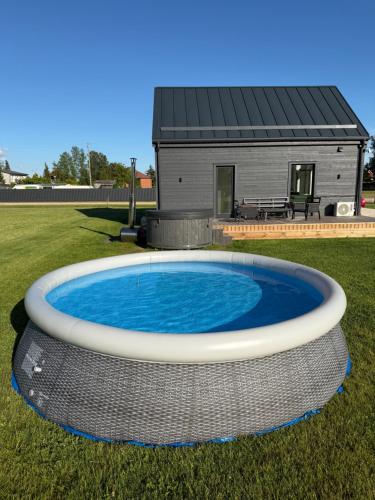 a large circular pool in front of a house at REAL House in Vītoliņi