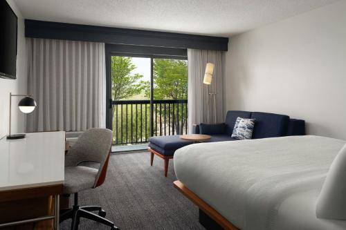 a hotel room with a bed and a desk and a window at Courtyard by Marriott Valdosta in Valdosta