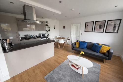 a living room with a couch and a kitchen at Modern 2 Bed Flat, Free Parking, Central Hemel in Hemel Hempstead