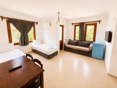 a living room with two beds and a table at Kilim Hotel & Apart in Fethiye