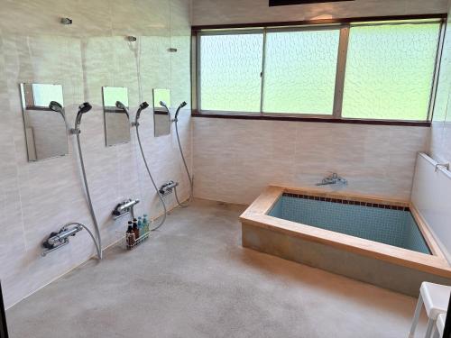 a bathroom with a tub and a shower and a sink at Tanigawa Valley Lodge & Coffee Roastery in Minakami