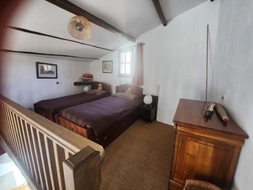 a bedroom with a bed and a desk in a room at Le bateau sur les toits in Cotignac