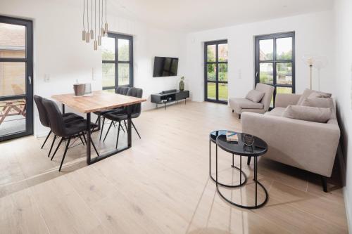 a living room with a table and a couch at Küsten Suite Nord - direkte Wasserlage, Terrasse, 70qm in Greetsiel