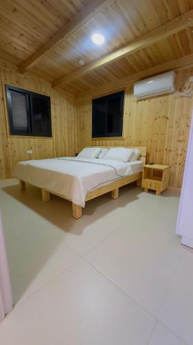 a bedroom with a bed in a wooden room at צימרים שדות אור in Maʼor