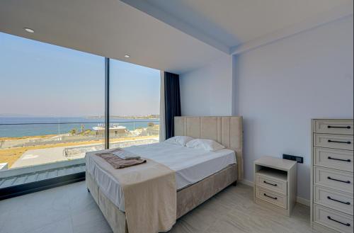 a bedroom with a bed and a view of the ocean at FOR LARGE FAMILIES, DUPLEX Vılla-304 in Çeşme
