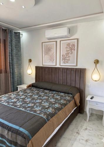 a bedroom with a bed and two lights on the wall at Armonia buglaow residence MARSA MDIQ in M'diq