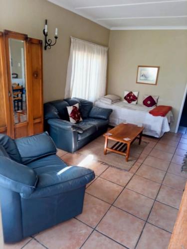 a living room with a couch and a bed at Alpha Self-Catering in Sutherland