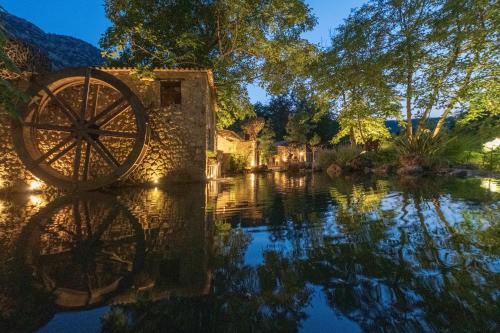 a woodenoked wheel sitting in the water of a river at Area Synest Nature Suites in Sinevrón
