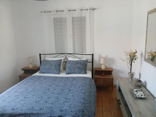 una camera da letto con un letto blu con due cuscini di Bei Konstantinos a Mesopótamon