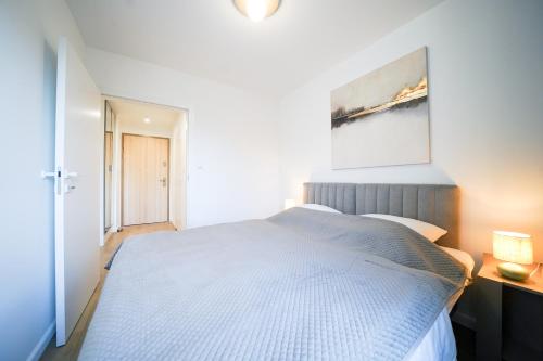 a bedroom with a bed and a painting on the wall at Apartbaltic- Ventus Park 5 in Świnoujście