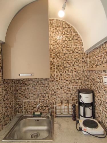 a kitchen with a sink and a brick wall at Dar Bourri in Al Matlīn
