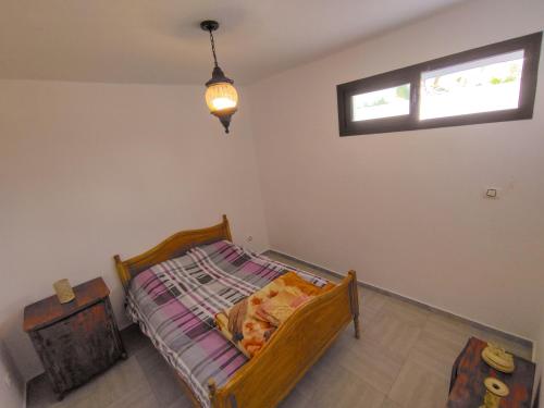 a small bedroom with a bed and a window at Dar Bourri in Al Matlīn