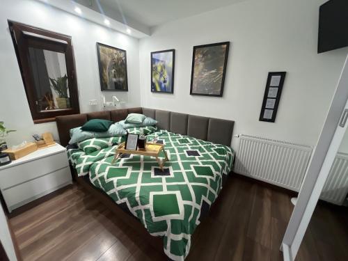 a bedroom with a bed with a green and white comforter at Apartament Crooked stairs in Zielona Góra